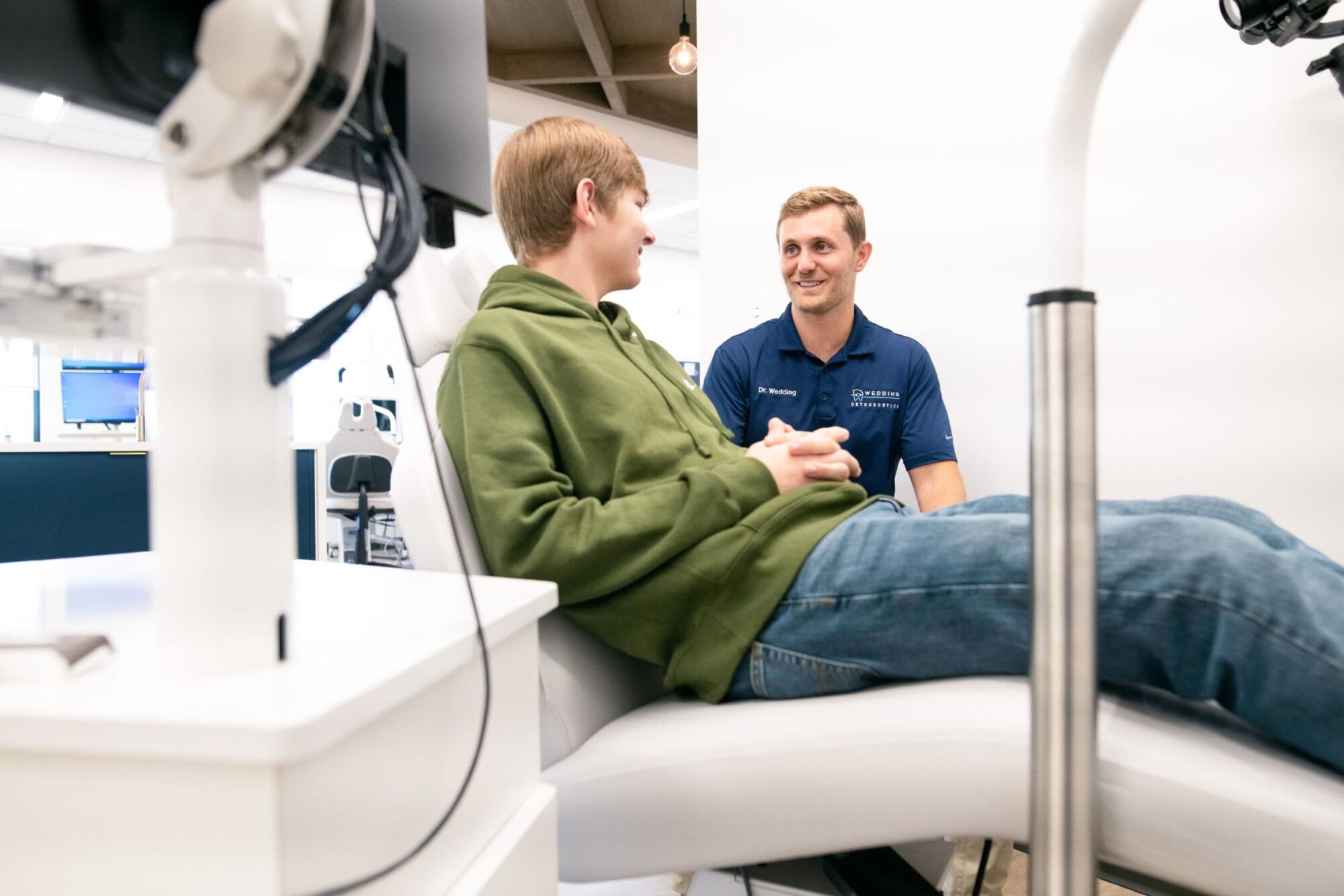 Dr. Wedding consulting with a patient in a modern orthodontic office, focusing on Invisalign treatment options at Wedding Thompson Orthodontics in Henderson.